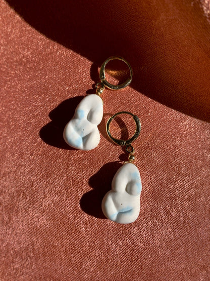 Pair of earrings with gold hoop on a red background