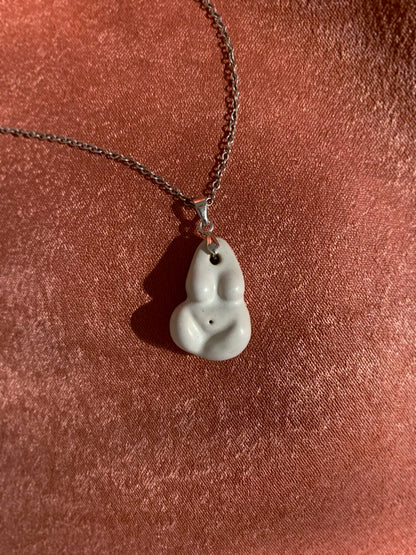 Necklace with a unique pendant with sterling silver bail on a textured red surface